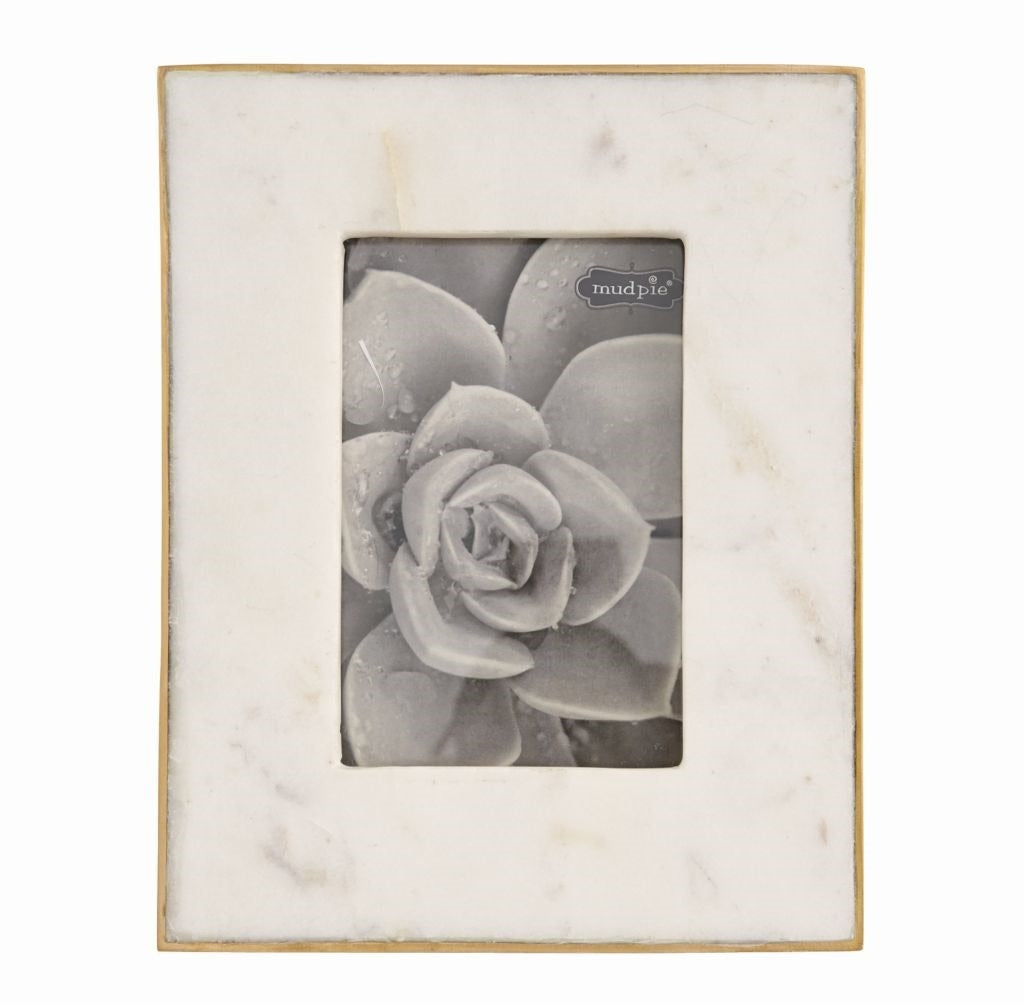 White marble picture frame with gold foil textured raw edge holding a photo