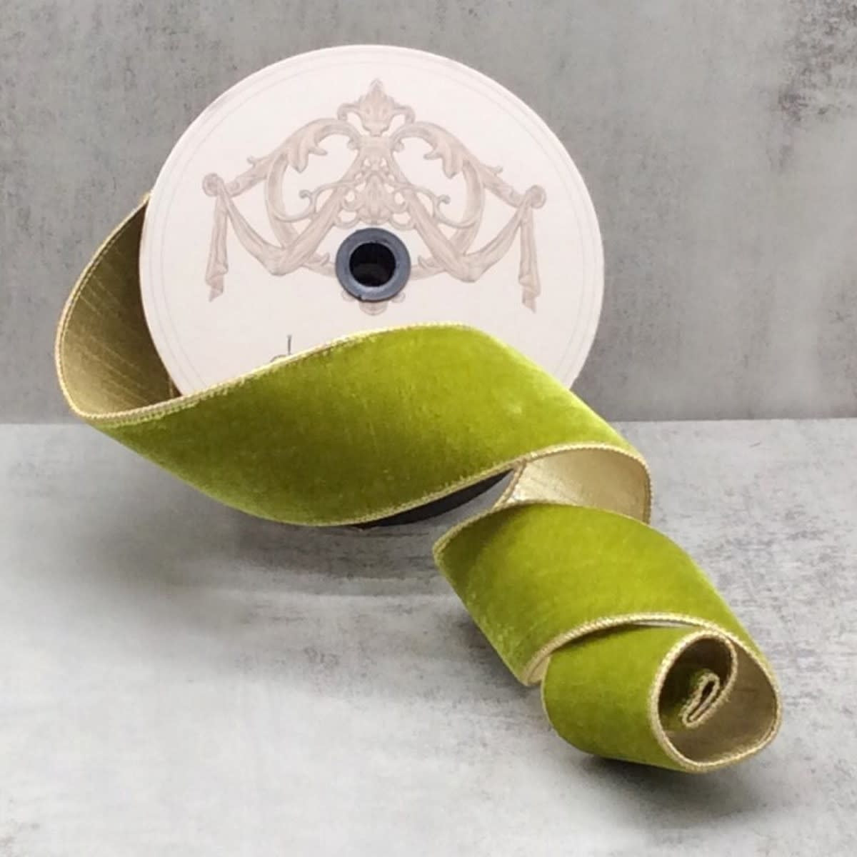 2.5-inch moss green velvet ribbon with gold edges on a spool.