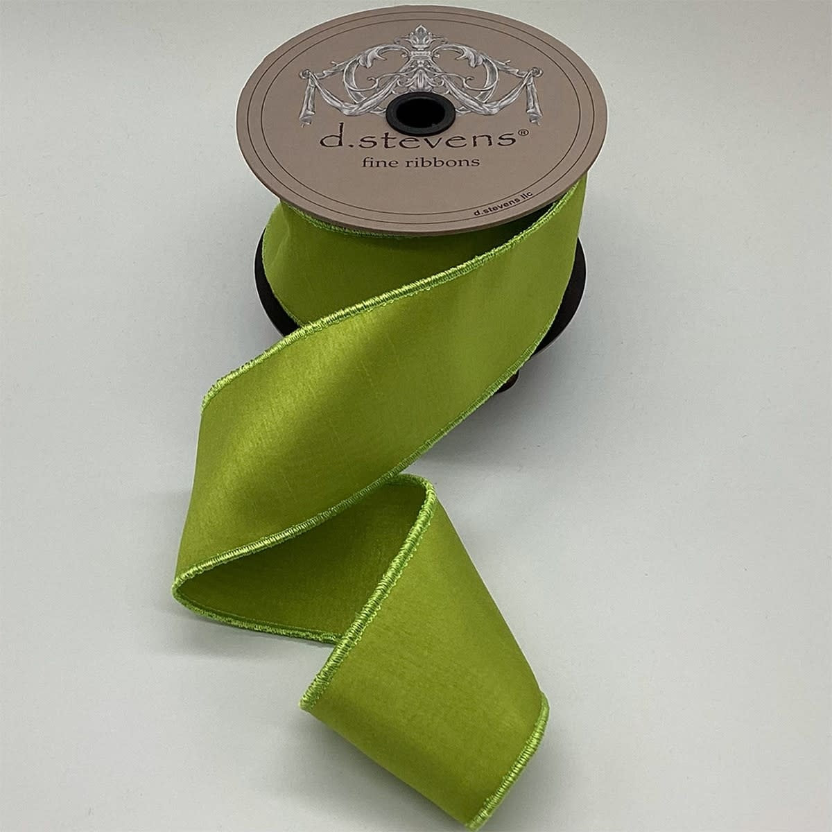 A spool of 2.5-inch wide lime green faux dupion ribbon with a stitched edge.