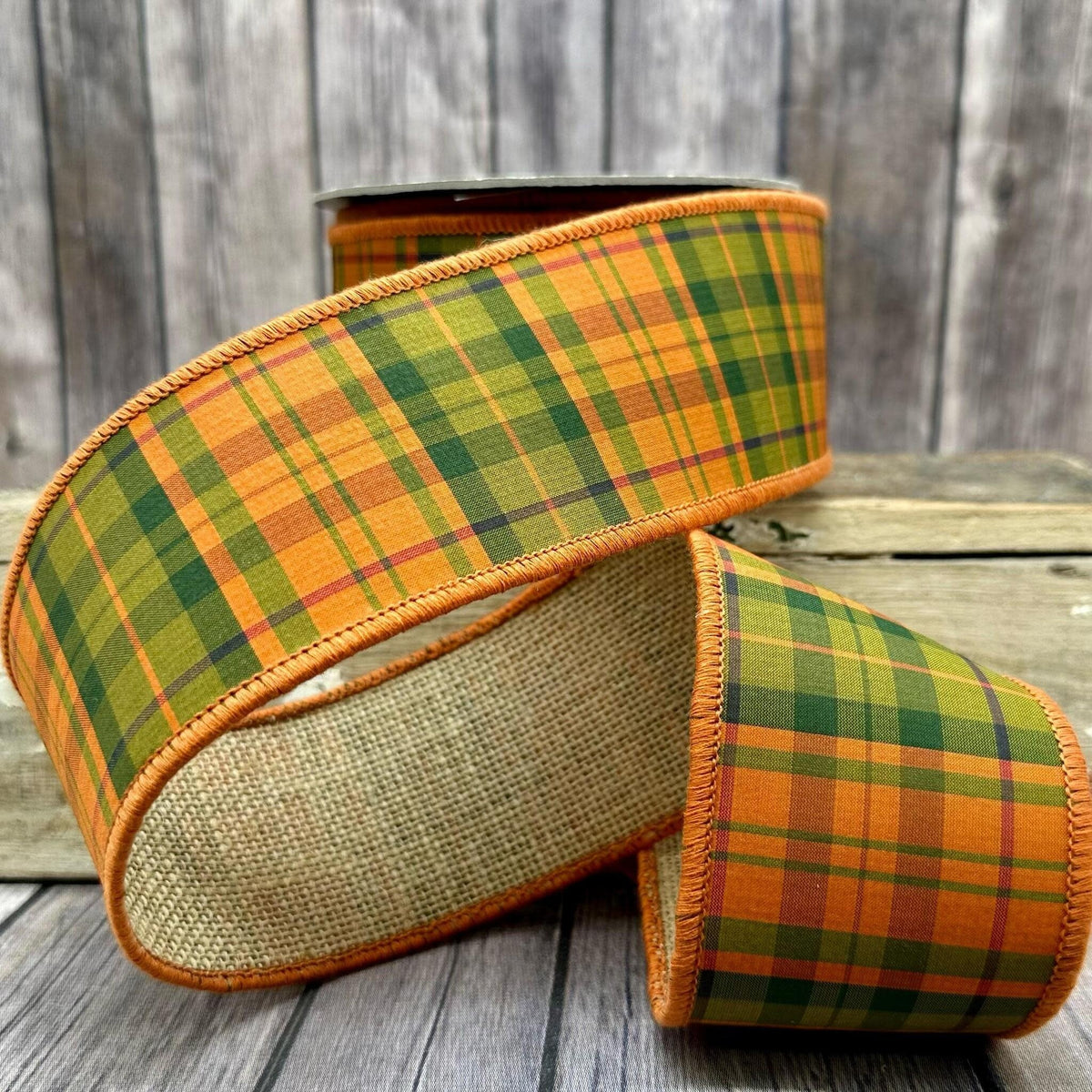 2.5-inch wide orange and green plaid burlap ribbon on a spool.