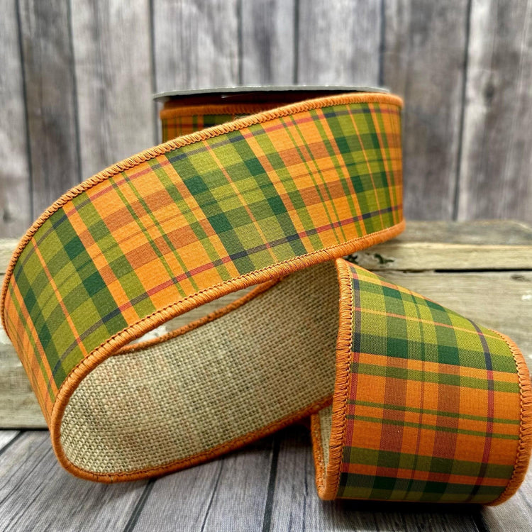 2.5-inch wide orange and green plaid burlap ribbon on a spool.