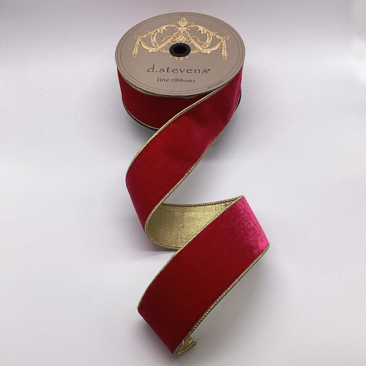 Spool of hot pink velvet ribbon with a metallic gold backing and gold-trimmed edges.