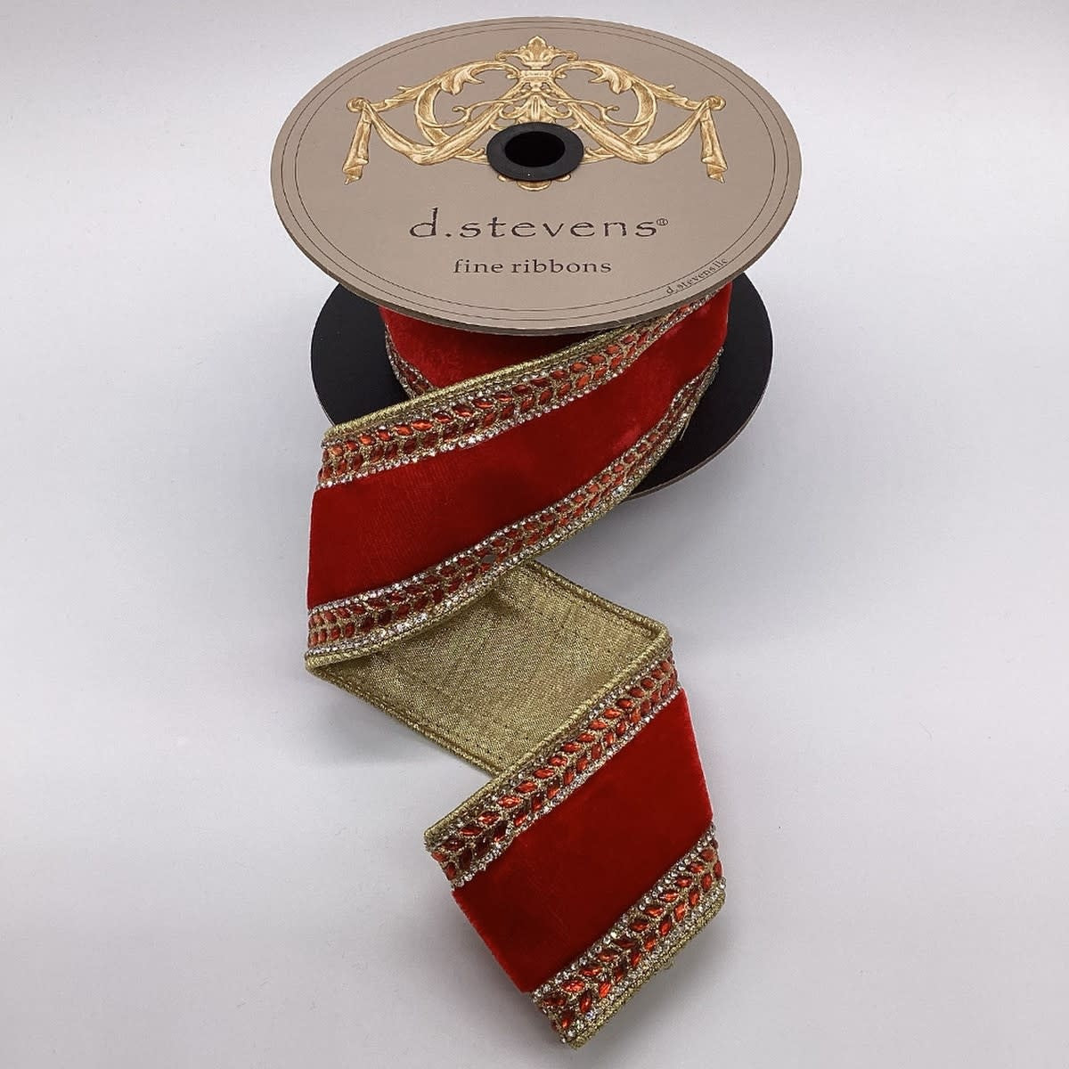 Red velvet ribbon with gold edges and crystal jewel side trim on a d.stevens spool.