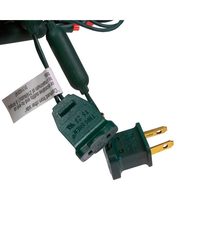 Green electrical plug and socket for LED string lights with a warning label attached.
