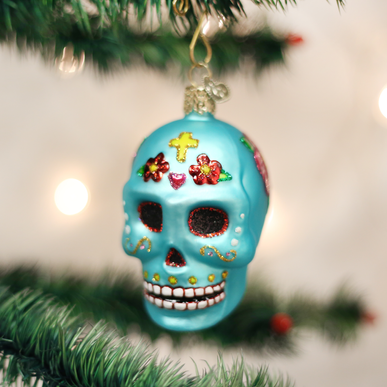 Day of the Dead ornament featuring a sugar skull with floral patterns in orange, black, and white.