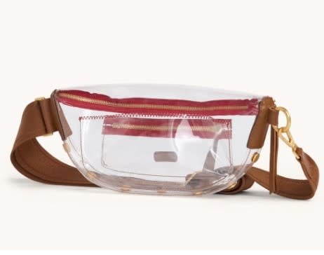 Clear stadium bag with mahogany pebbled leather accents, brushed gold hardware, and red zipper.