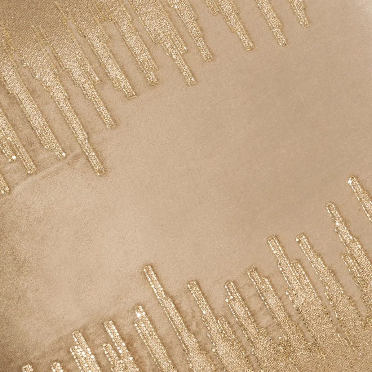 Square beige velvet pillow with abstract gold embroidery thread beading on front.