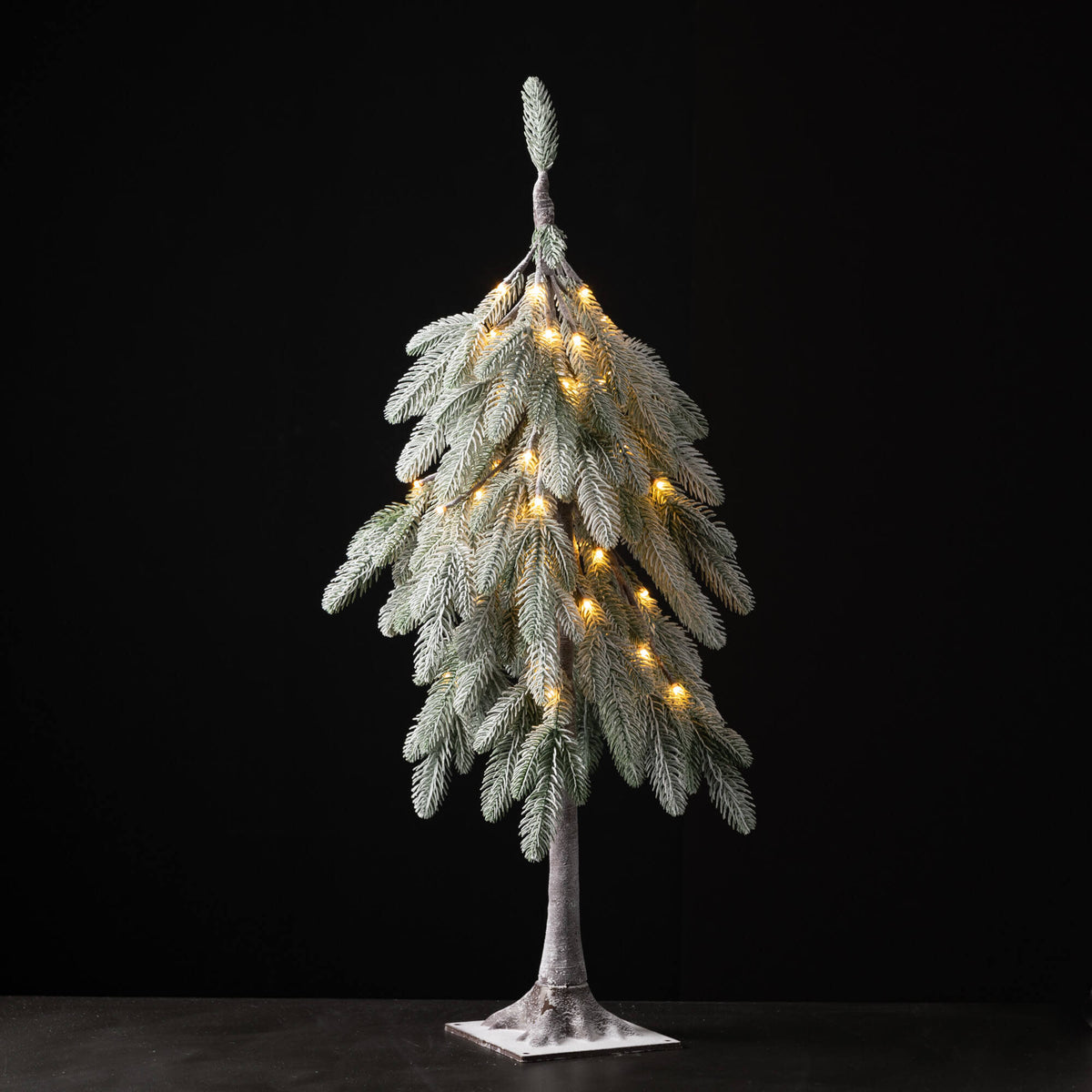 3-foot tall artificial flocked Christmas tree with warm white lights and a droopy silhouette.