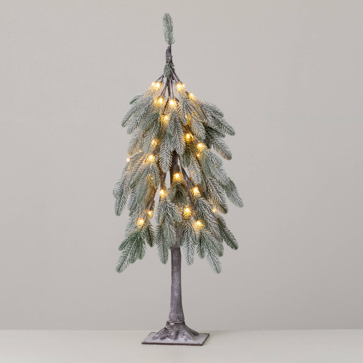 3-foot tall artificial flocked Christmas tree with drooping branches and warm white LED lights.