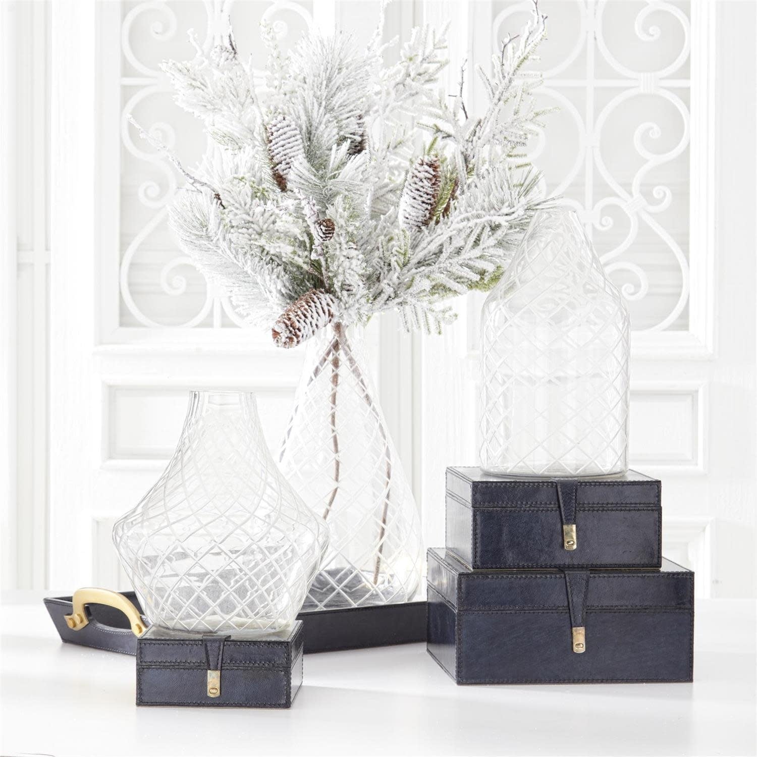 Glittered, heavy flocked pine stem with pinecones in a clear diamond-patterned glass vase.
