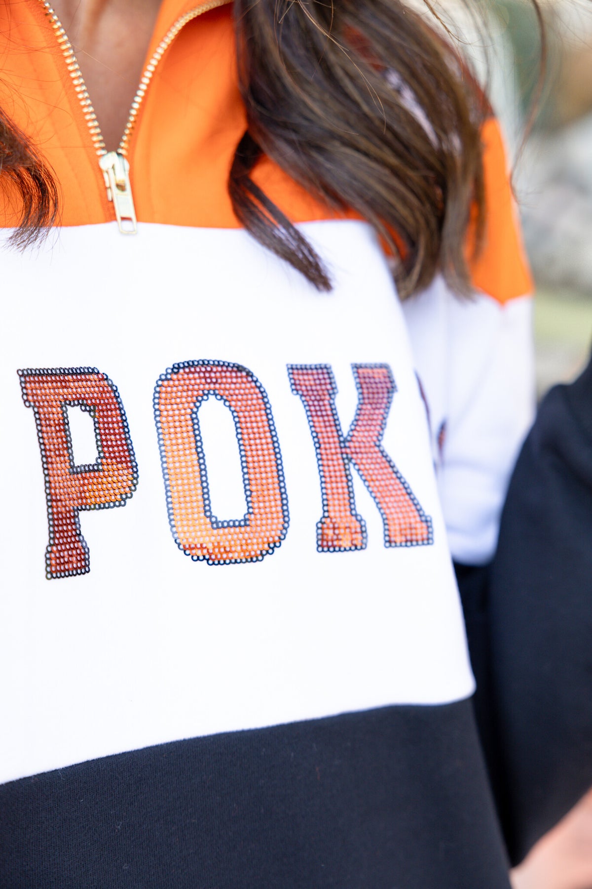 Orange and black quarter-zip sweatshirt with colorblock panels representing OSU team colors.