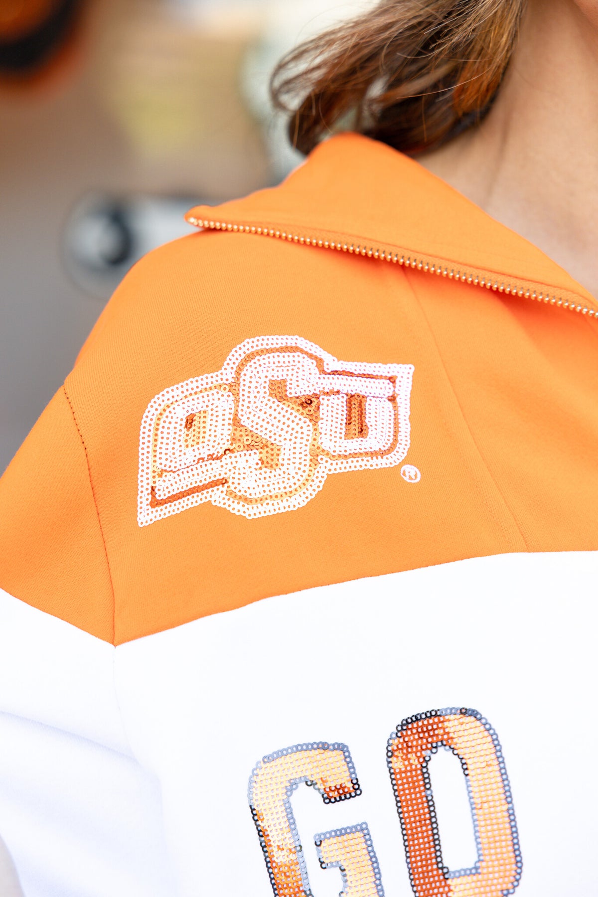 Orange and black quarter-zip sweatshirt with colorblock panels representing OSU team colors.