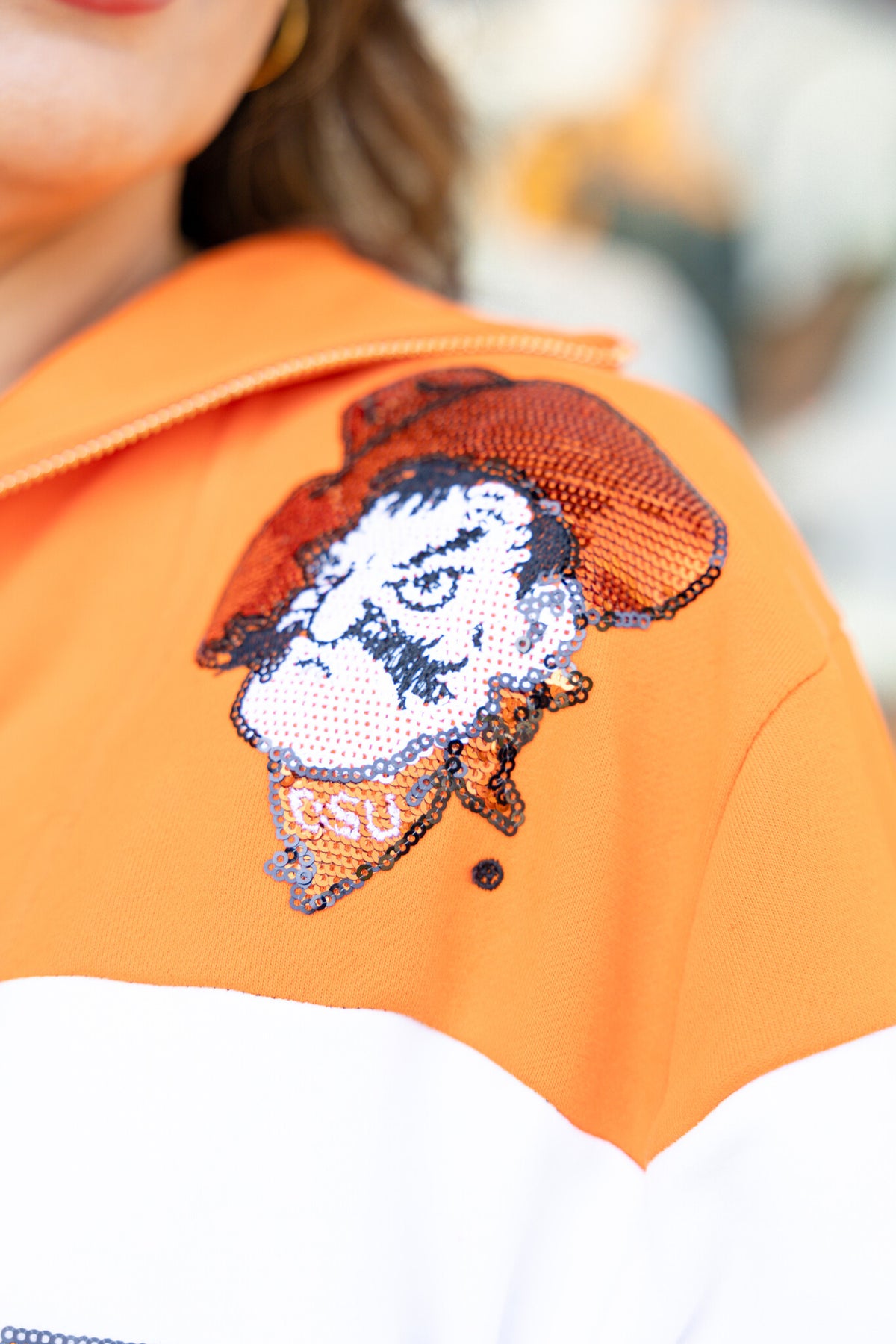 Orange and black quarter-zip sweatshirt with colorblock panels representing OSU team colors.