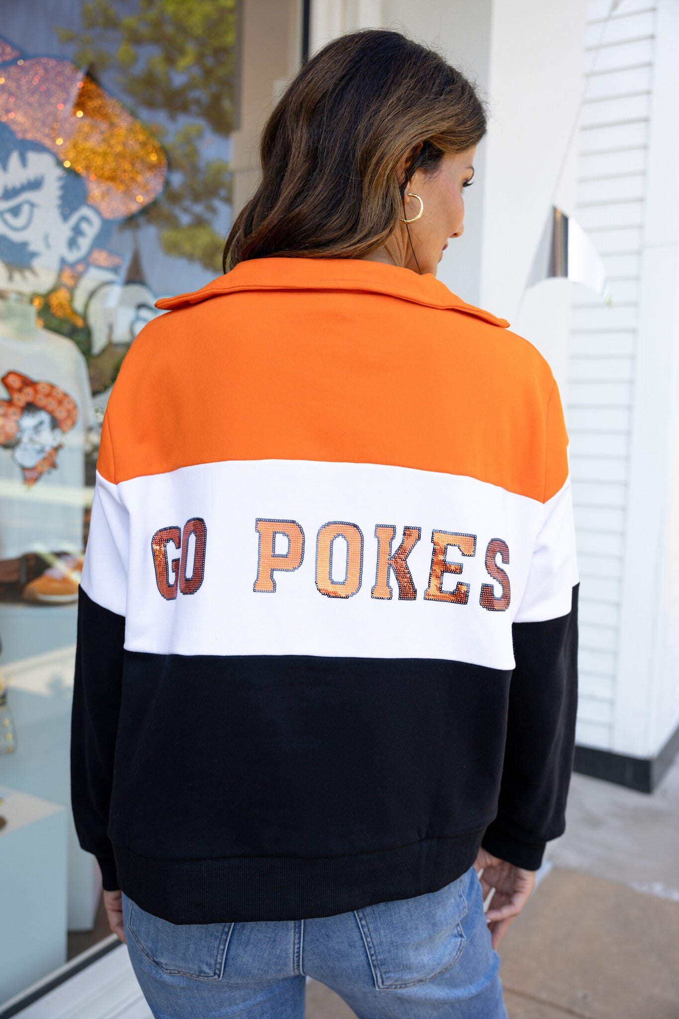 Orange and black quarter-zip sweatshirt with colorblocking representing OSU team colors.