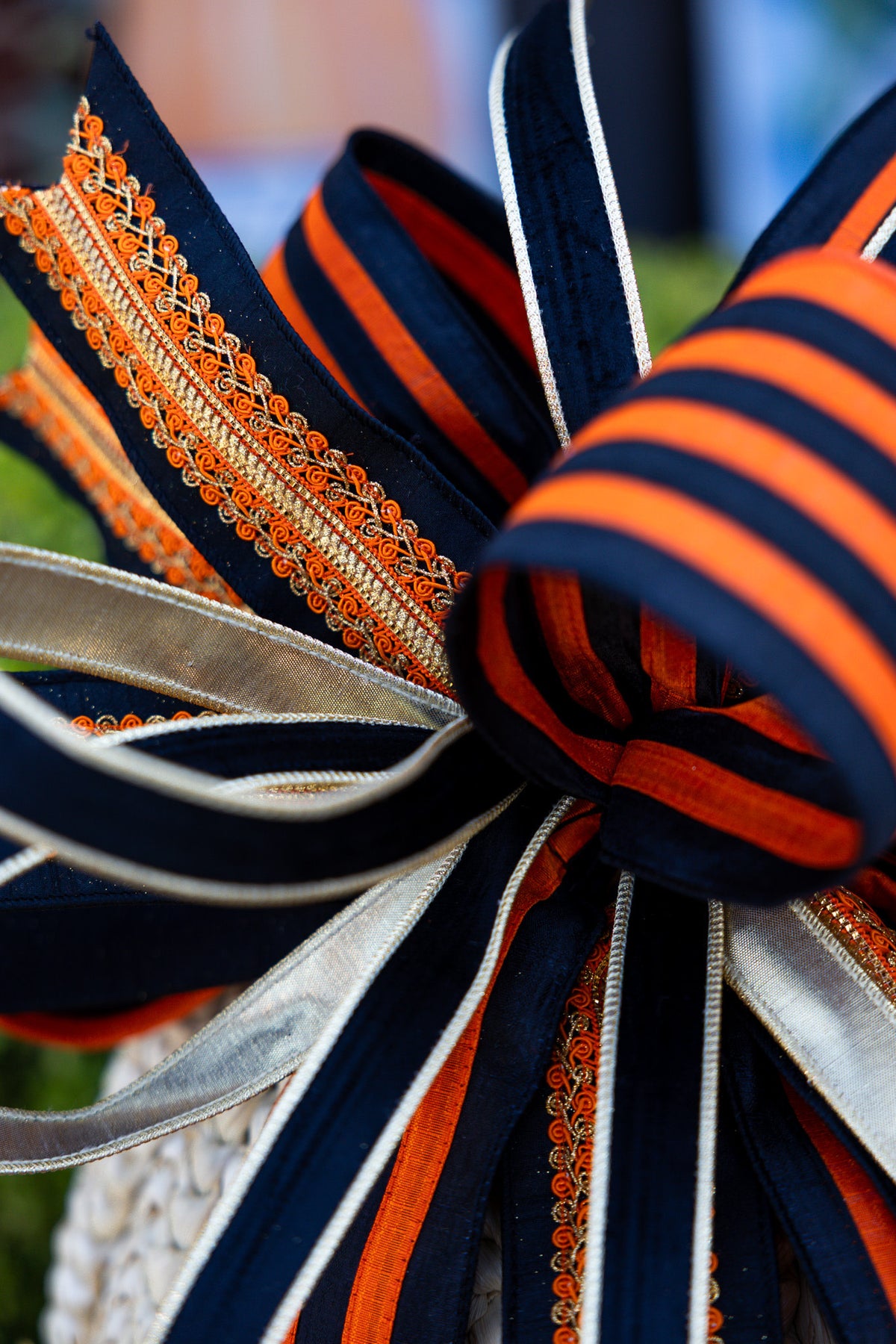 Large orange and black striped ribbon bow with a central knot.