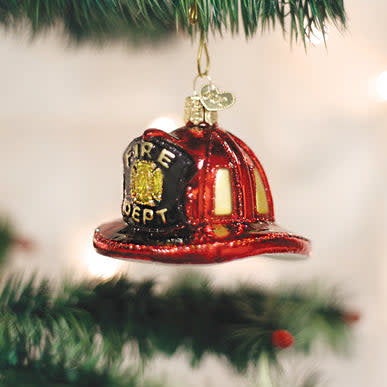Red fireman helmet ornament with gold shield emblem on black background