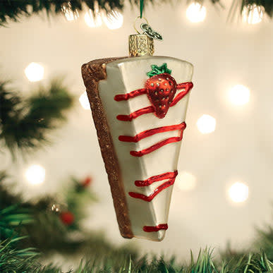 Red ceramic cheesecake ornament with white frosting swirls on a gold stick.