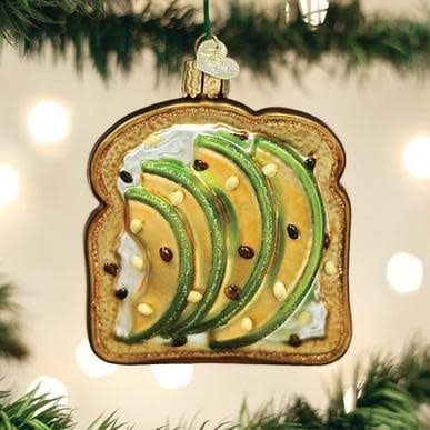 Green avocado toast ornament with crusty bread slice topped by sliced avocado.