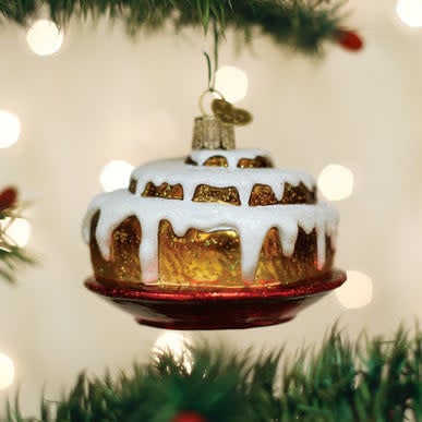 Cinnamon roll ornament with swirled brown icing on a white background.