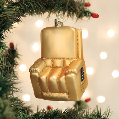 Small recliner-shaped ornament in cream fabric with a curved backrest.