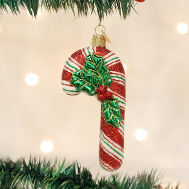 Red candy cane shaped Christmas ornament with white stripes hanging from a gold hook.
