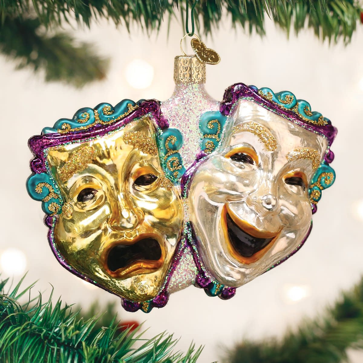 Comedy And Tragedy ornament featuring classic Greek theater masks with exaggerated expressions on a white background.