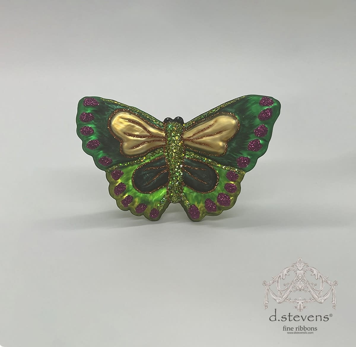 3.75-inch green glass butterfly ornament with gold wings and purple glitter accents.