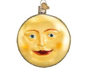 Man in the Moon ornament with a dark celestial figure on a light background.