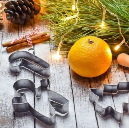 Stainless steel Christmas cookie cutter set with festive shapes in a metal container.