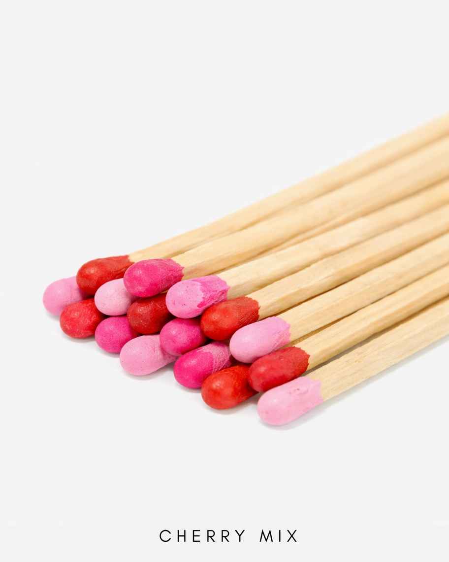 A bundle of three-inch safety matches with heads in various shades of pink and red.