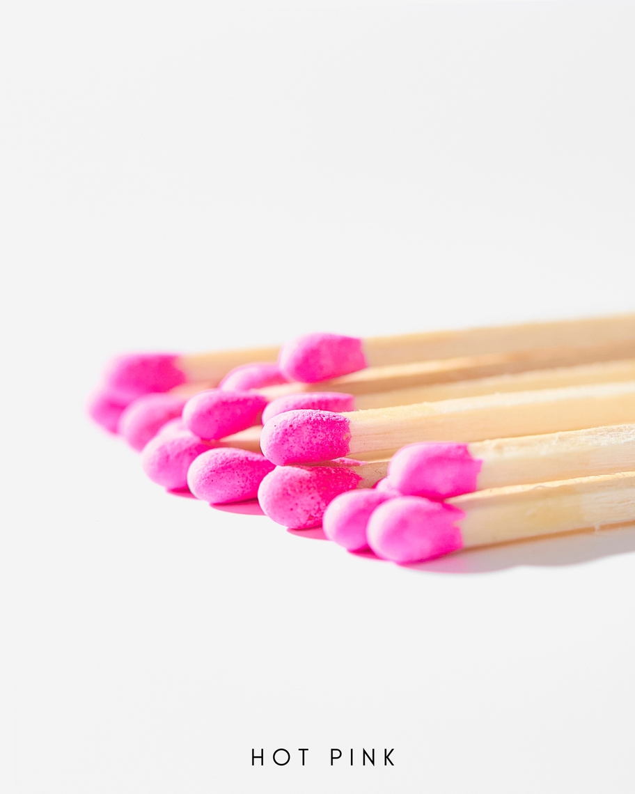 A bundle of 3-inch safety matches with hot pink tips and natural wood sticks on a white background.