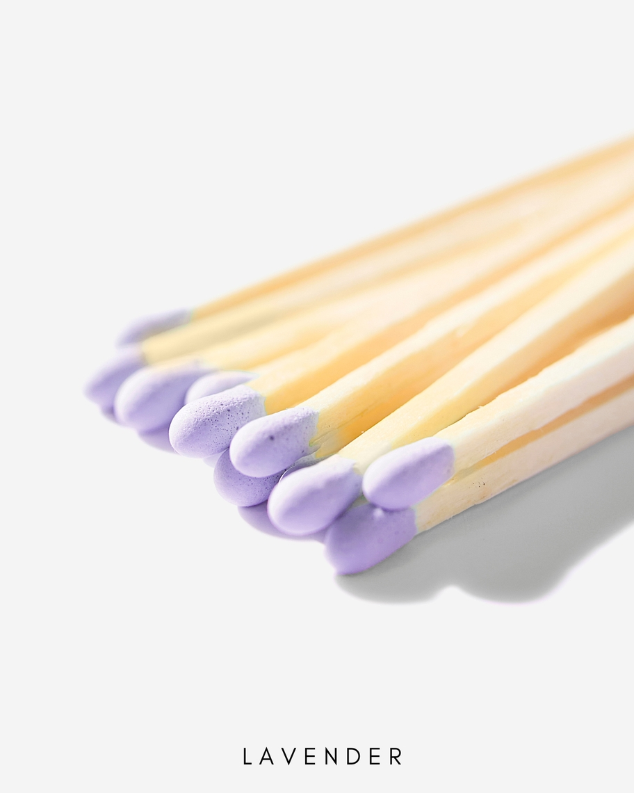 Close-up of 3-inch wooden safety matches with lavender purple tips against a white background.