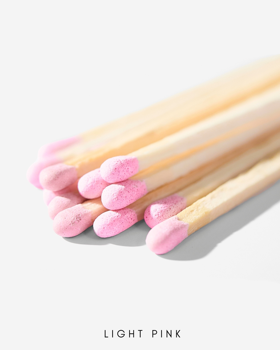 Close-up of 3-inch wooden safety matches with light pink tips bundled together.