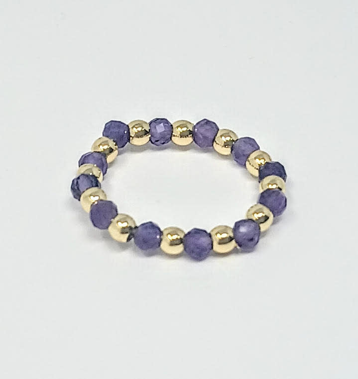 A beaded ring featuring alternating 3mm gold-tone balls and faceted purple semi-precious stones.