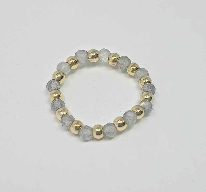 A ring featuring alternating 3mm gold-tone beads and faceted grey semi-precious stone beads.