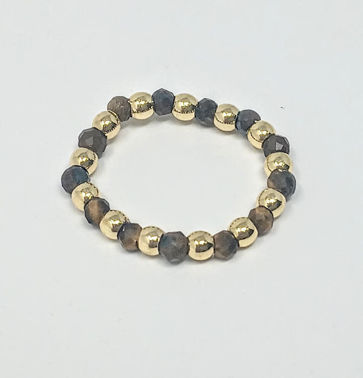 A ring featuring alternating 3mm gold-tone beads and faceted dark grey semi-precious stones.