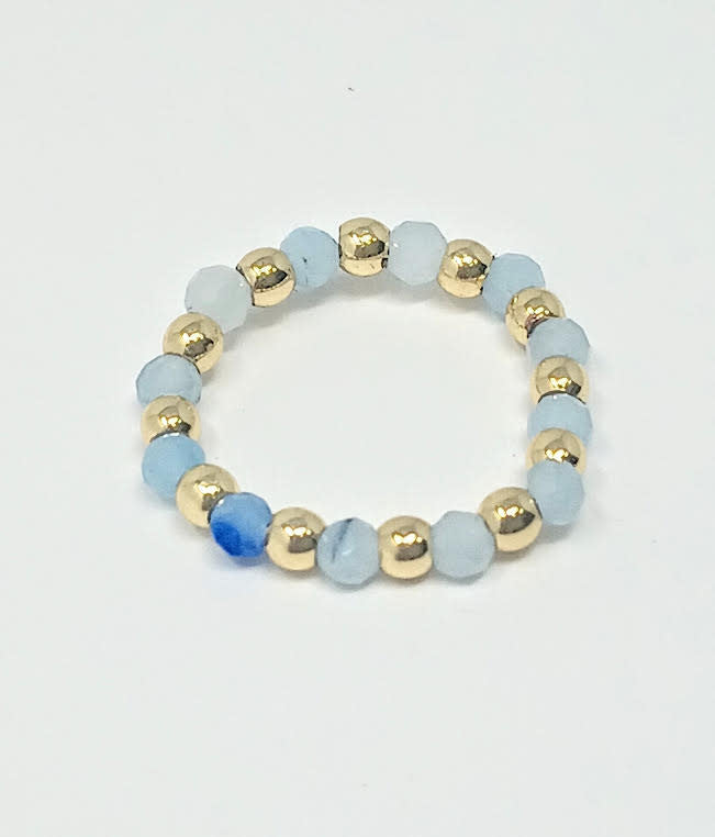 A beaded ring featuring alternating gold-tone metallic spheres and light blue semi-precious stones.