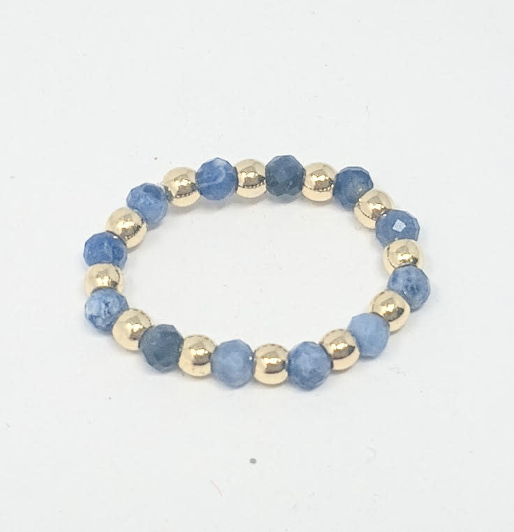 Beaded ring featuring alternating 3mm gold-tone balls and faceted blue semi-precious stones.