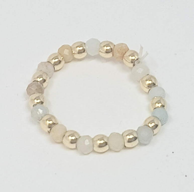 A stretch ring featuring 3mm gold-tone beads alternating with faceted semi-precious stones.