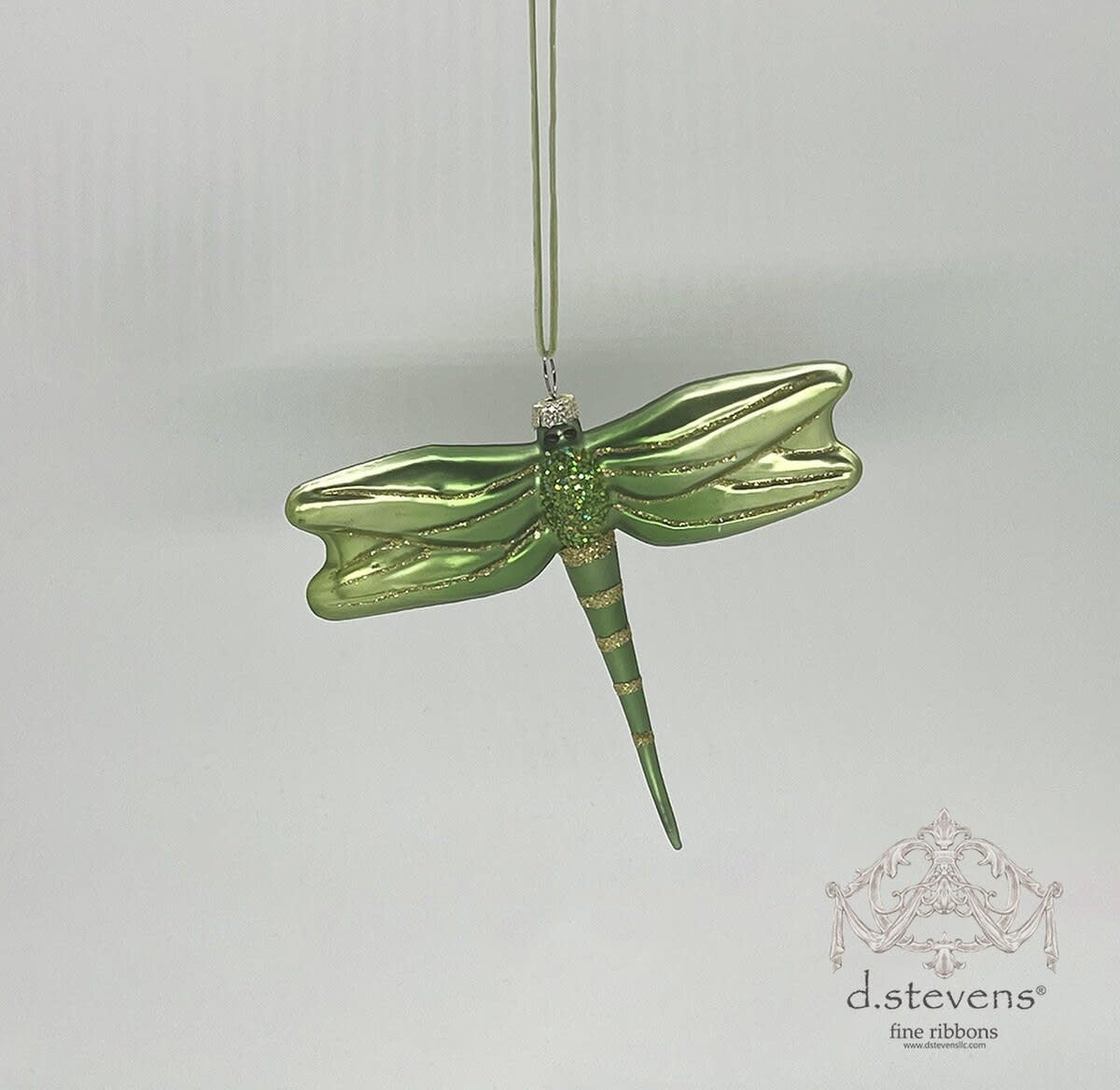 A 4-inch green glass dragonfly ornament with gold glitter accents on its wings and body.