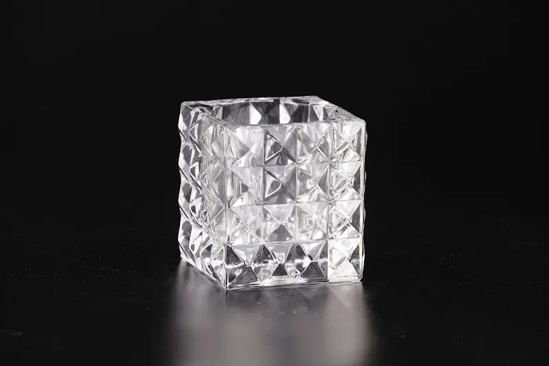 Clear glass vase with a square shape measuring four inches tall.