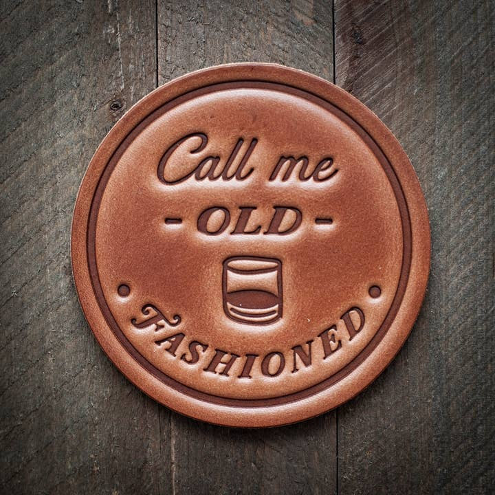 Four square leather coasters in a distressed brown finish with visible stitching.