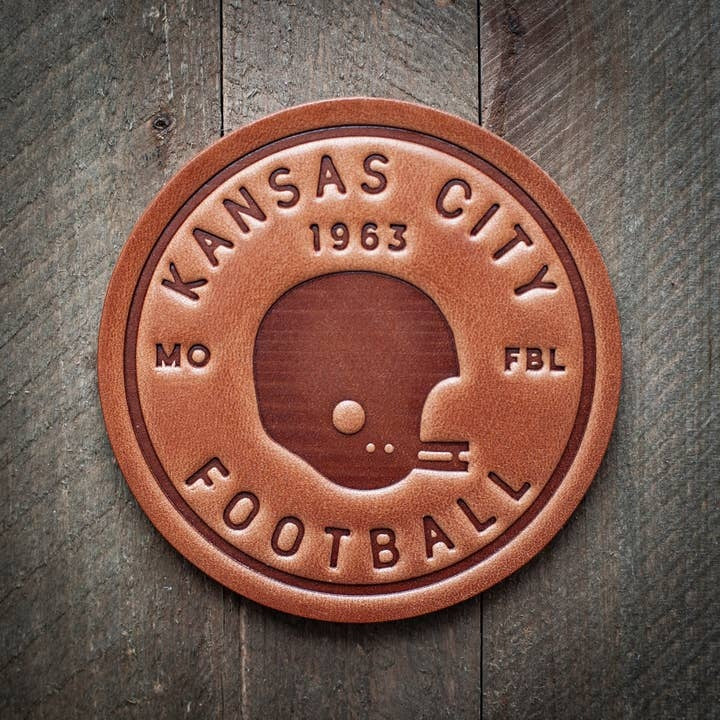 Four square leather coasters in Kansas City Chiefs colors with team logo pattern