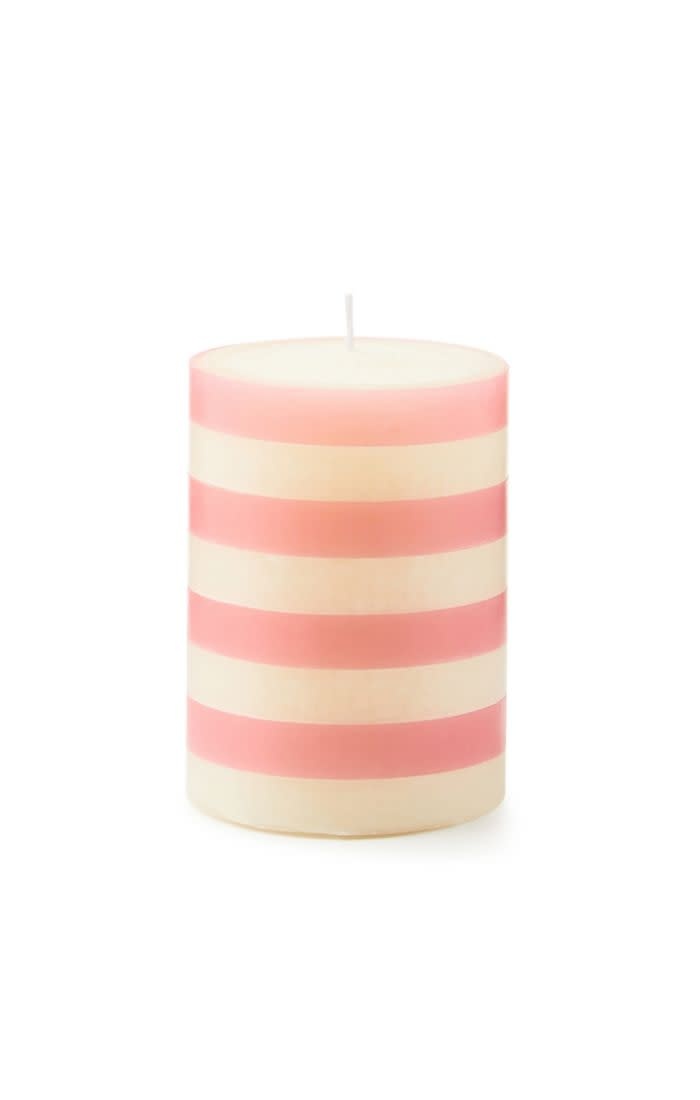 Pink pillar candle with four vertical bands on a cylindrical shape