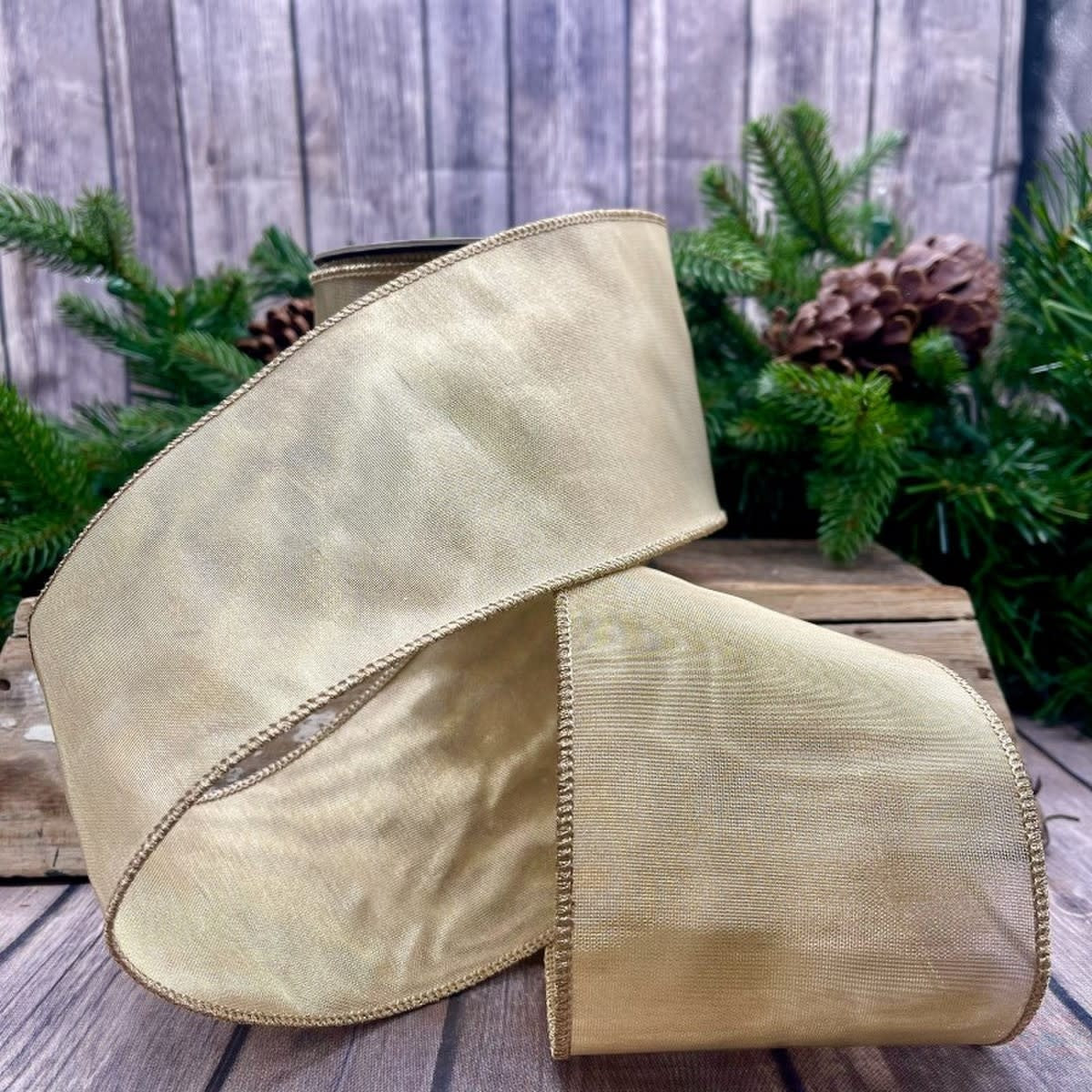 Gold metallic mesh fabric roll measuring four inches wide by ten yards long.