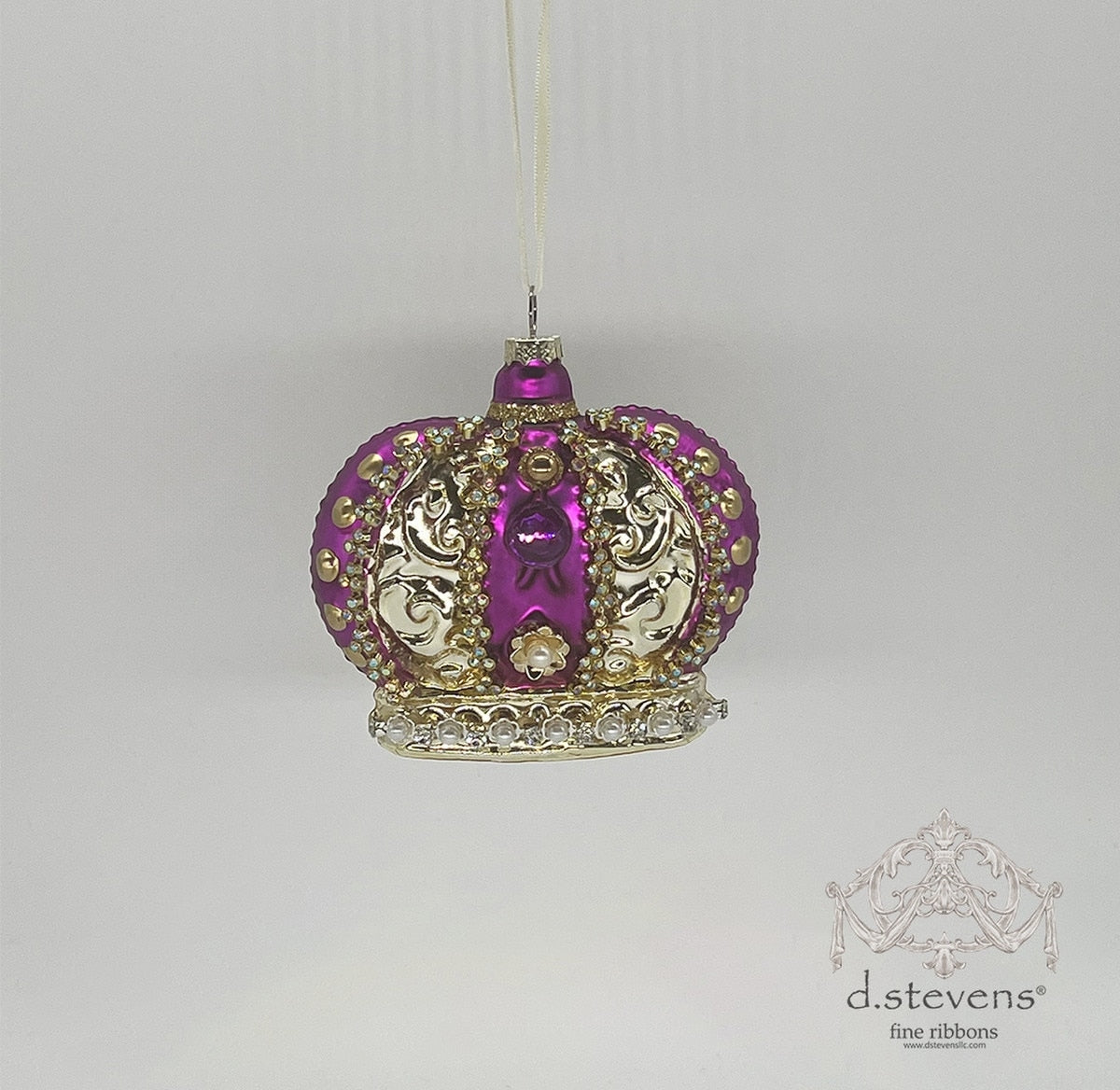 A 4.375-inch purple and gold glass crown ornament with intricate filigree and pearl accents.
