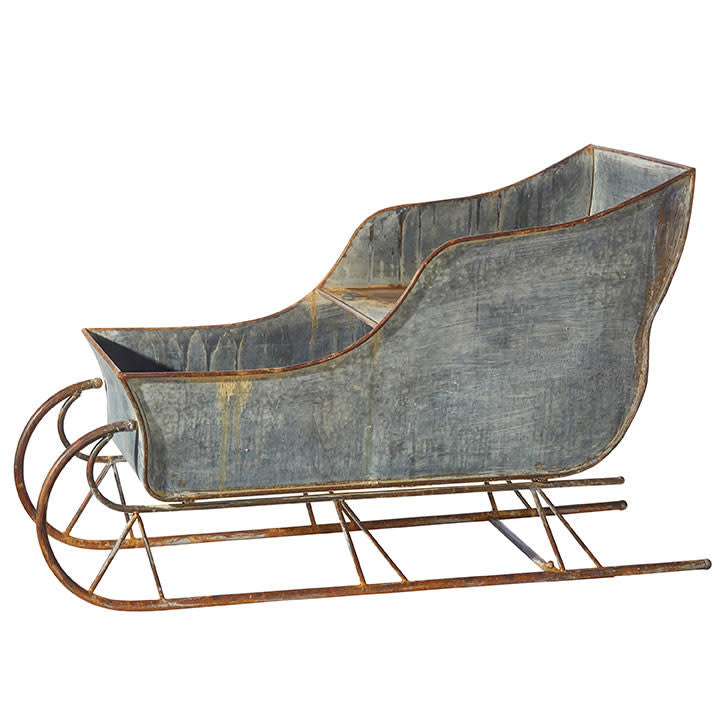 48-inch distressed galvanized iron sleigh with curved sides suitable for holiday figurine display.