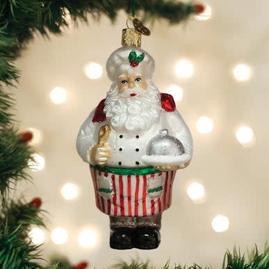 Red ceramic Santa chef ornament holding a ladle with kitchen background