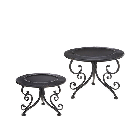 Two black iron risers with distressed finish, round tops, and decorative swirl legs.