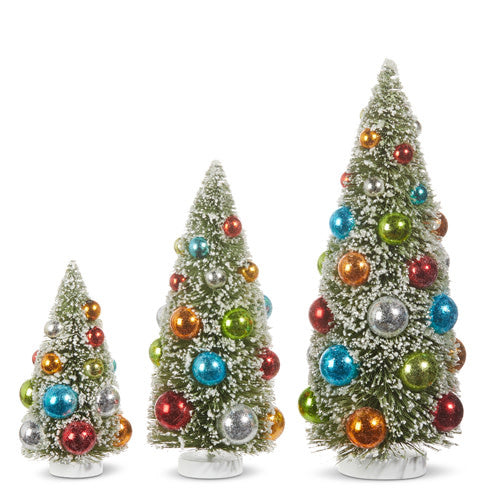 Snowy sisal bottle brush tree ornament with wooden accents and festive plastic decorations.